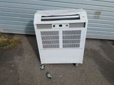 a white electric heater on the ground next to a garage door