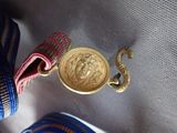 a gold coin sitting on top of a blue and white bag