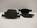 two black brake pads on a white surface with a white background