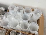a box of plastic cups sitting on the floor next to a box of plastic cups