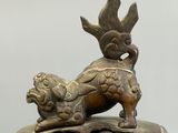 bronze statue of a lion on a pedestal with a bird on top