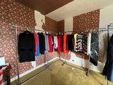 a lot of clothes hanging on a rack in a room