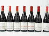 six bouteilles de vin alignées sur une surface blanche
