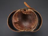 an old leather helmet with a leather band and a leather cap