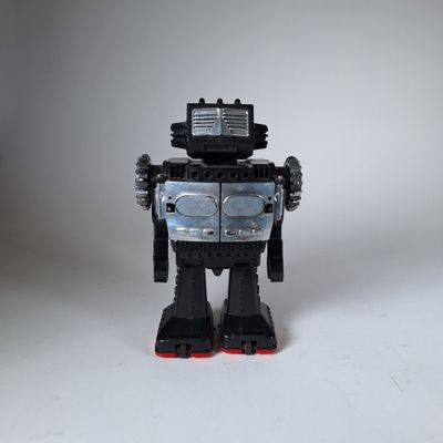 un robot jouet posé sur une surface blanche