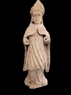 une vieille statue représentant une femme coiffée d'un chapeau et vêtue d'une robe