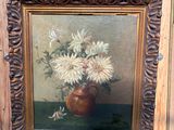 une photo d'un tableau représentant des fleurs dans un vase, posé sur un chevalet