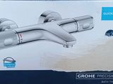 un carton contenant le nouveau robinet de salle de bains Grohe, encore dans son emballage d'origine