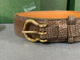 brown snake skin belt with gold buckle on a table