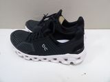 the black and white running shoe is on a white surface