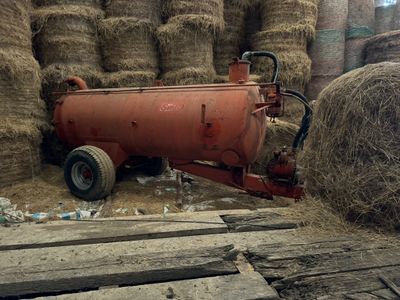 un tracteur garé à côté d'un tas de foin