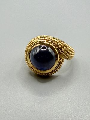 une image d'une bague en or avec une pierre bleue au centre