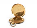 a gold pocket watch with a chain on a white background