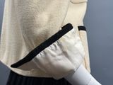 une photo d'un mannequin portant une veste blanche et une jupe noire