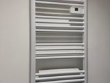 un radiateur-séchoir à serviettes blanc, fixé au mur