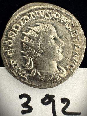 une pièce en argent avec l'image d'un homme portant une coiffe