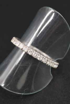 un gros plan d'une bague posée sur un présentoir transparent