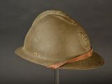 an old helmet on a stand on a gray background