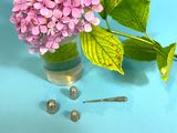 a vase of flowers and a pair of earrings on a table