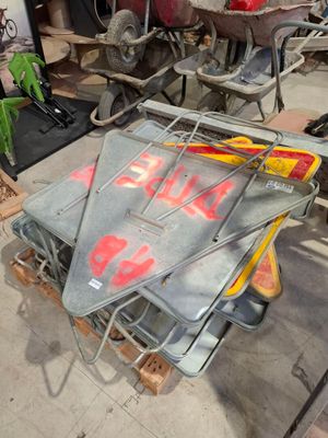 un chariot métallique sur lequel est accrochée une pancarte, dans un garage
