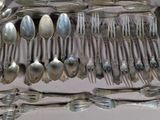 a lot of silver spoons and spoon spoons on the table
