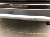 a close up of a car ' s bumper with a hole in it