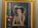 a painting of a woman in a hat on a wall