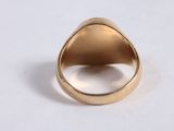 a close up of a gold ring on a white surface