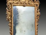 un miroir sculpté avec un cadre doré sur fond noir