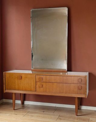 une commode en bois surmontée d'un miroir