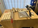une table recouverte d'une nappe, sur laquelle se trouve un ordinateur portable