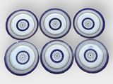 six blue and white plates with circular designs on them