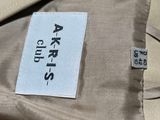 a label on the back of a beige jacket