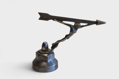 a statue of a man holding a knife on top of a bell