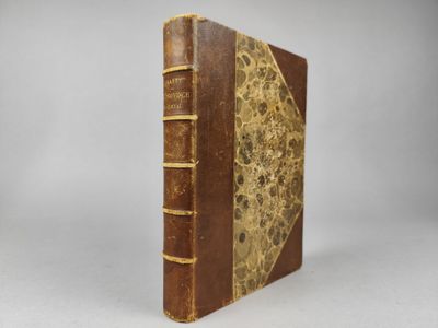 un vieux livre à la couverture brune posé sur une table