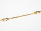gros plan d'un bracelet en or sur fond blanc