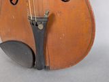 an old violin sitting on top of a table next to a white wall