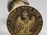 a brass seal with an eagle on it and a crown on top