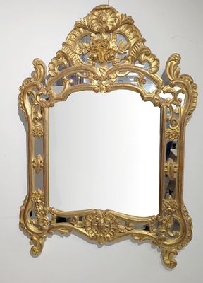 un miroir doré accroché au mur de la pièce