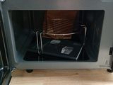 a microwave with a tray inside of it on a wooden floor