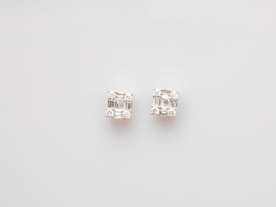 a pair of diamond earrings on a white background