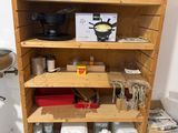 a wooden shelf with pots and pans on top of it