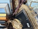 a box full of assorted framed and unframed pictures