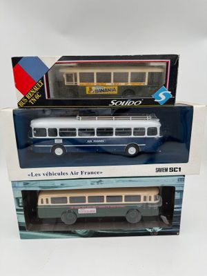 trois maquettes de bus dans leur boîte sont empilées les unes sur les autres