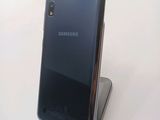 the back of a black samsung phone sitting on top of a metal stand