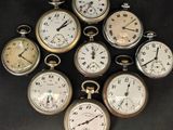 many different types of pocket watches on a black surface