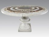 une table en marbre blanc dont le plateau présente un motif circulaire