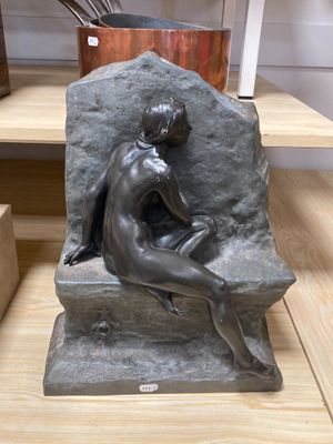 statue d'une femme assise sur un rocher dans une pièce