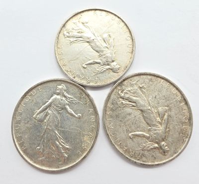trois pièces de monnaie britanniques empilées les unes sur les autres sur une surface blanche