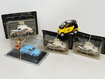 four toy cars in a display case on a table